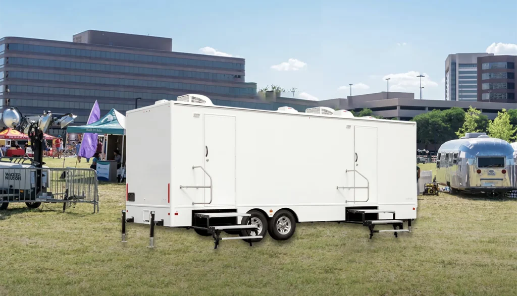 8 Station (2 Doors) Shower Trailer parked in the grass outside of a music festival