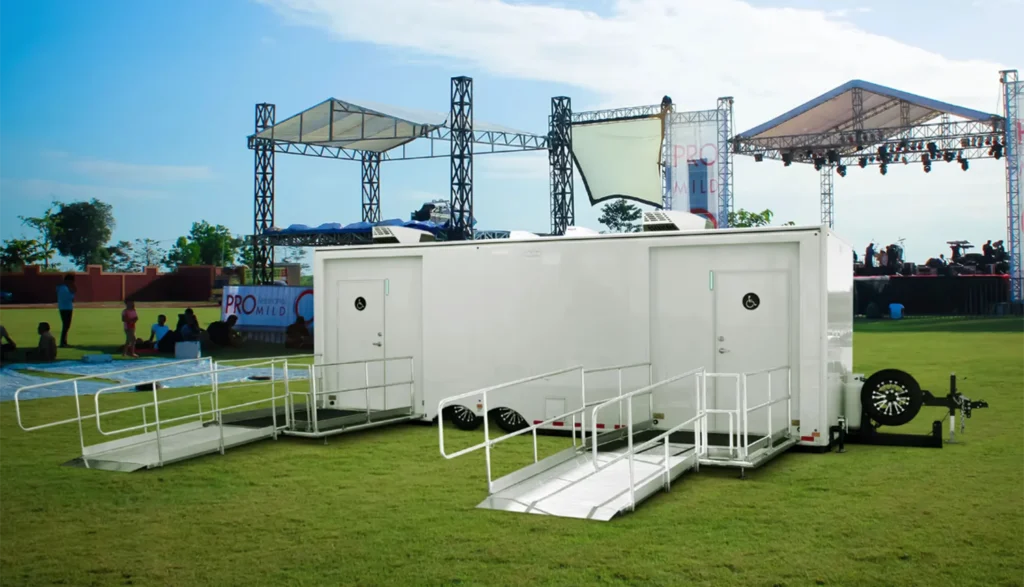 Wheelchair-accessible ADA Tandem Combo Trailer sitting on the lawn at an outdoor music festival event
